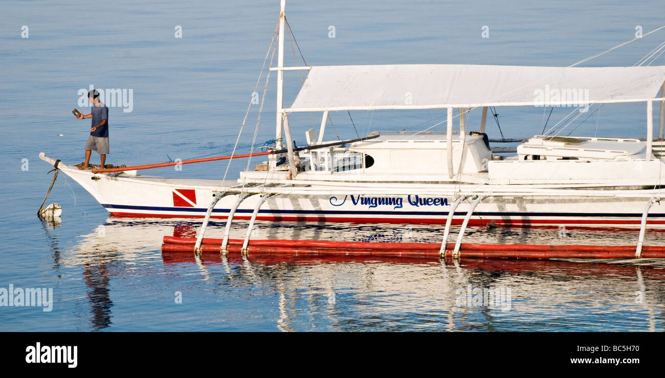 Un barcaiolo ottiene la sua nave pronto per una giornata di immersioni in Moalboal, Filippine Foto Stock