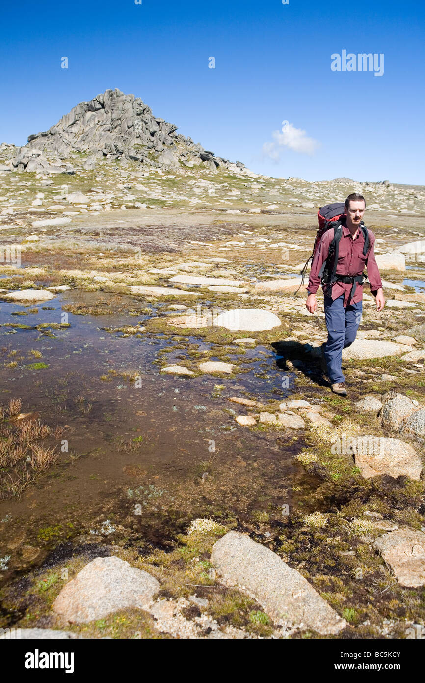 Bushwalker al di sotto del picco roccioso di Ramshead nel Kosciuszko National Park Foto Stock