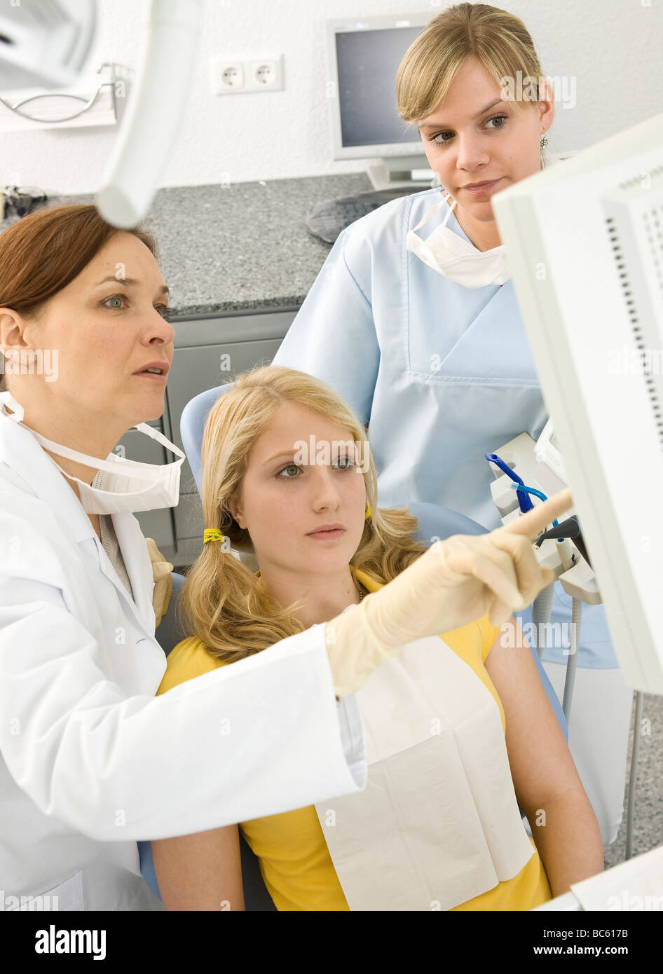 Dentisti femmina e il paziente guardando il monitor Foto Stock