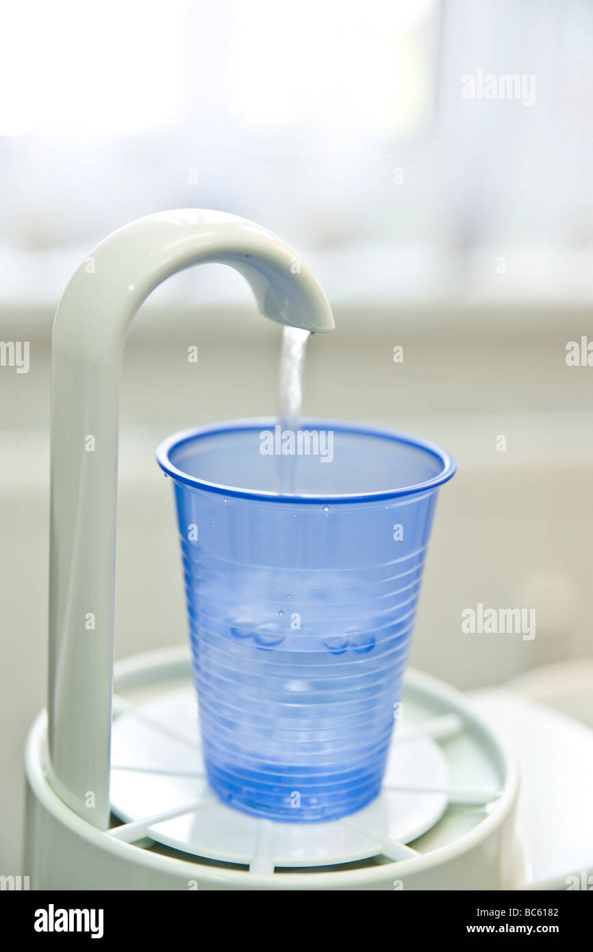 Close-up della tazza monouso sotto il rubinetto di acqua in studio dentistico Foto Stock