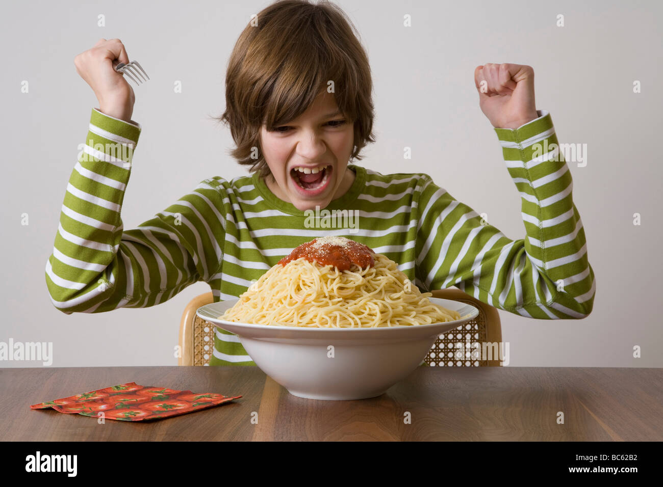 Germania, ragazzo circa a mangiare grande piatto di pasta Foto Stock