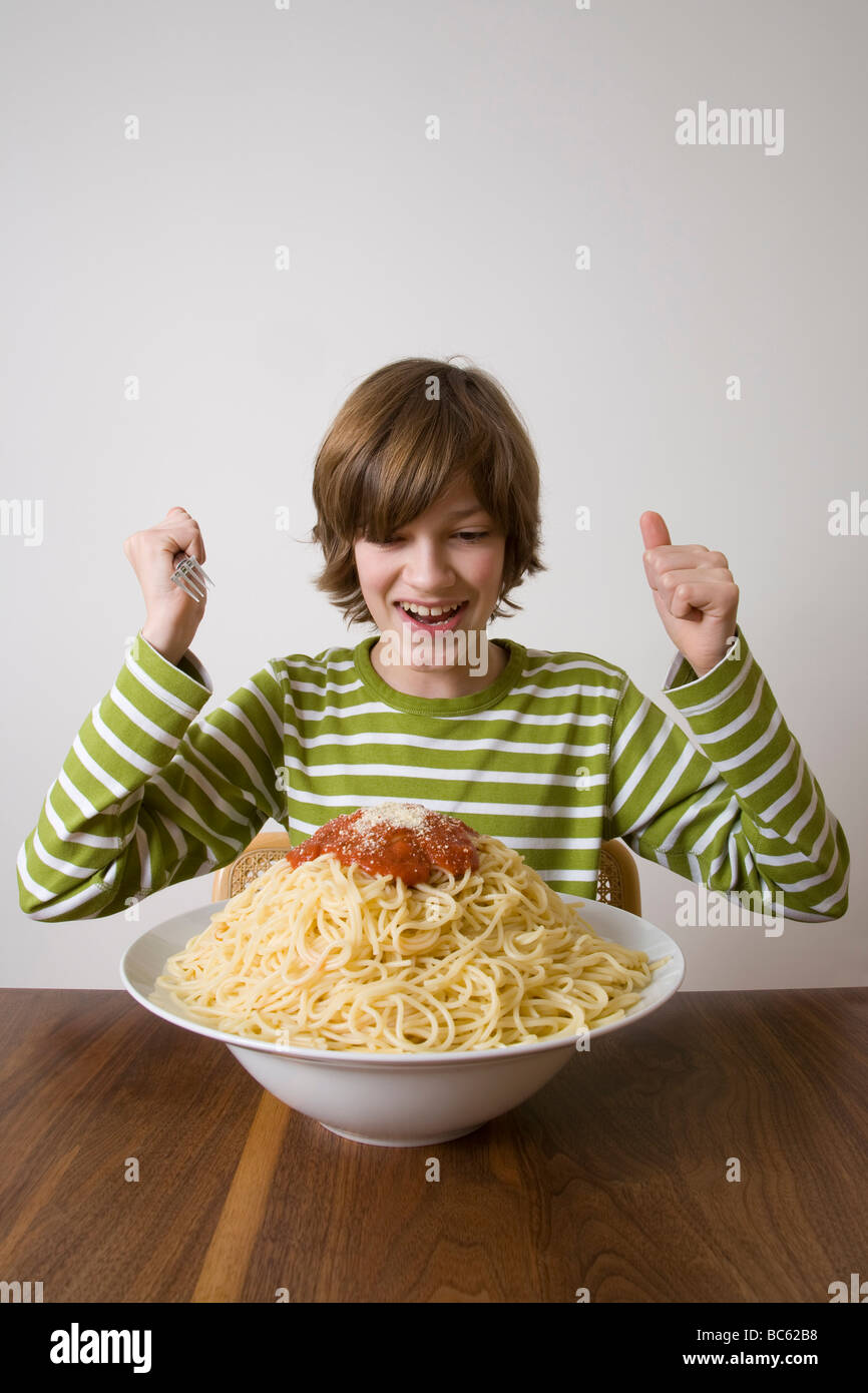 Germania, ragazzo circa a mangiare grande piatto di pasta Foto Stock