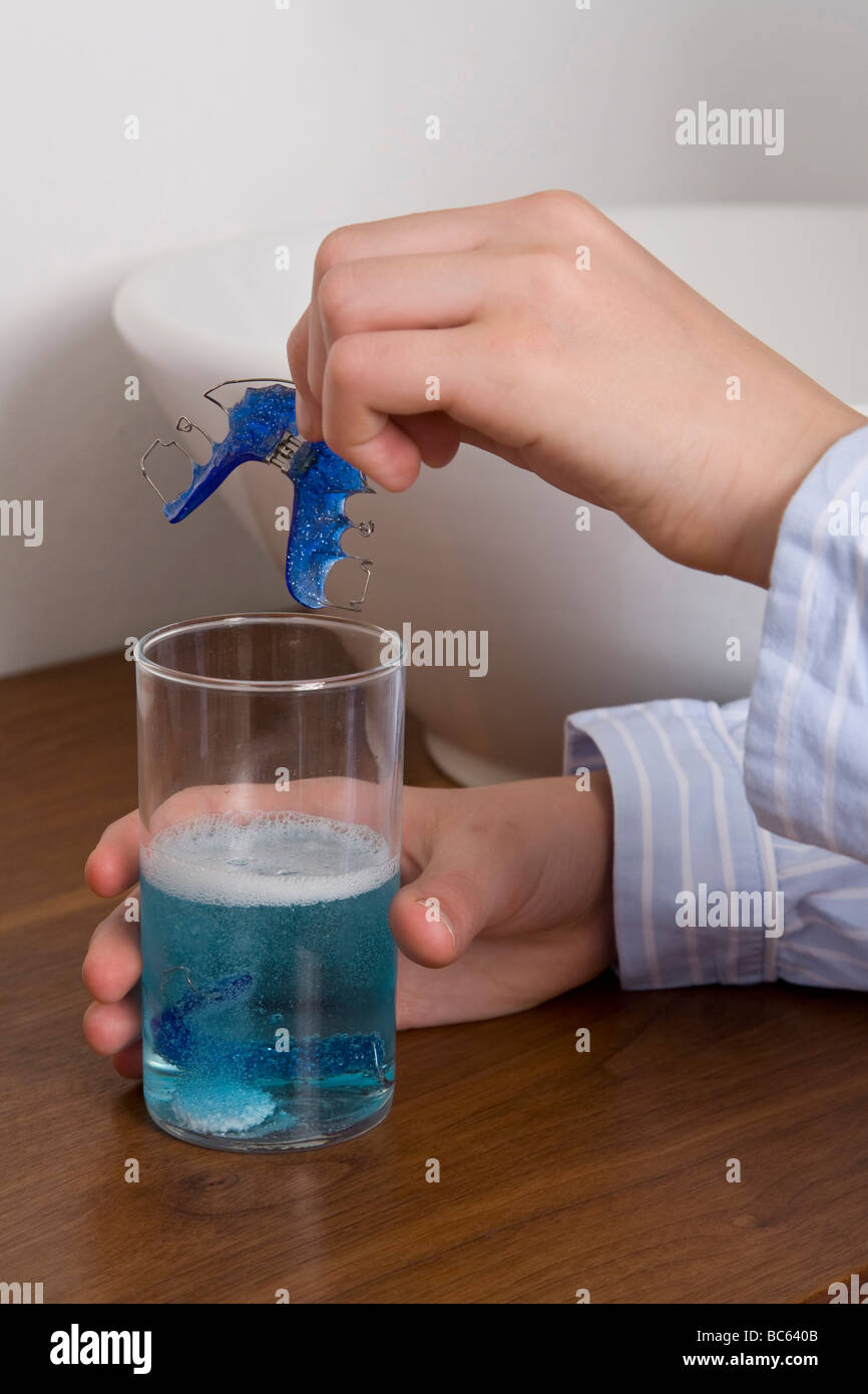 Bretelle di pulizia in un bicchiere di liquido Foto Stock