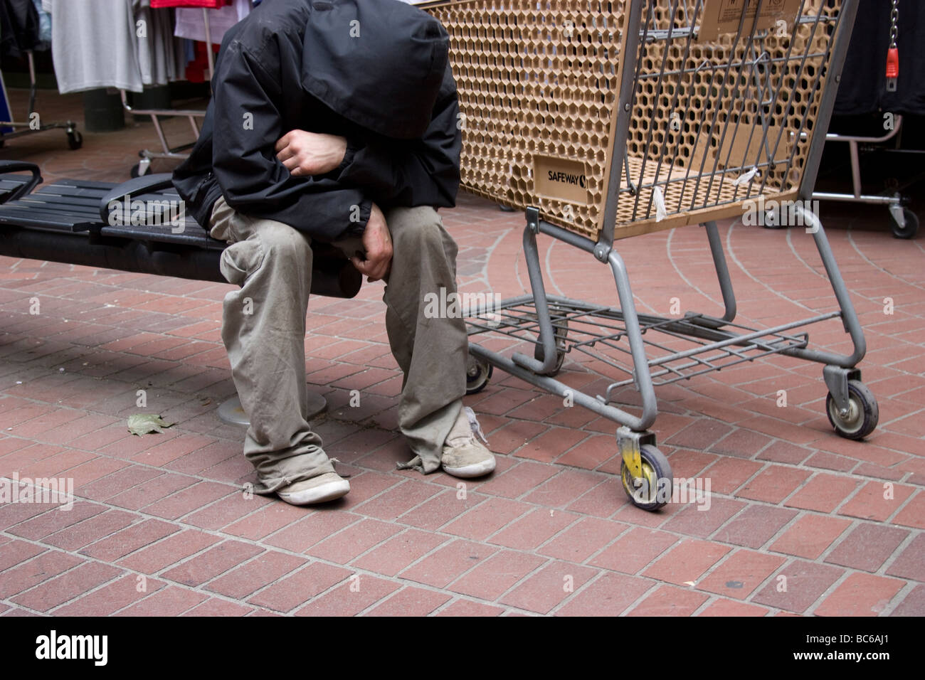 Ricchi poveri dividono la disuguaglianza, Vancouver Canada senzatetto con carrello della spesa Foto Stock