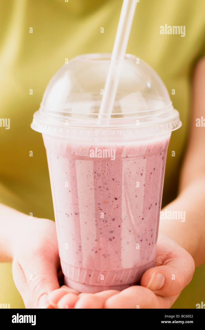 Mani frullato mirtillo nel becher in plastica - Foto Stock