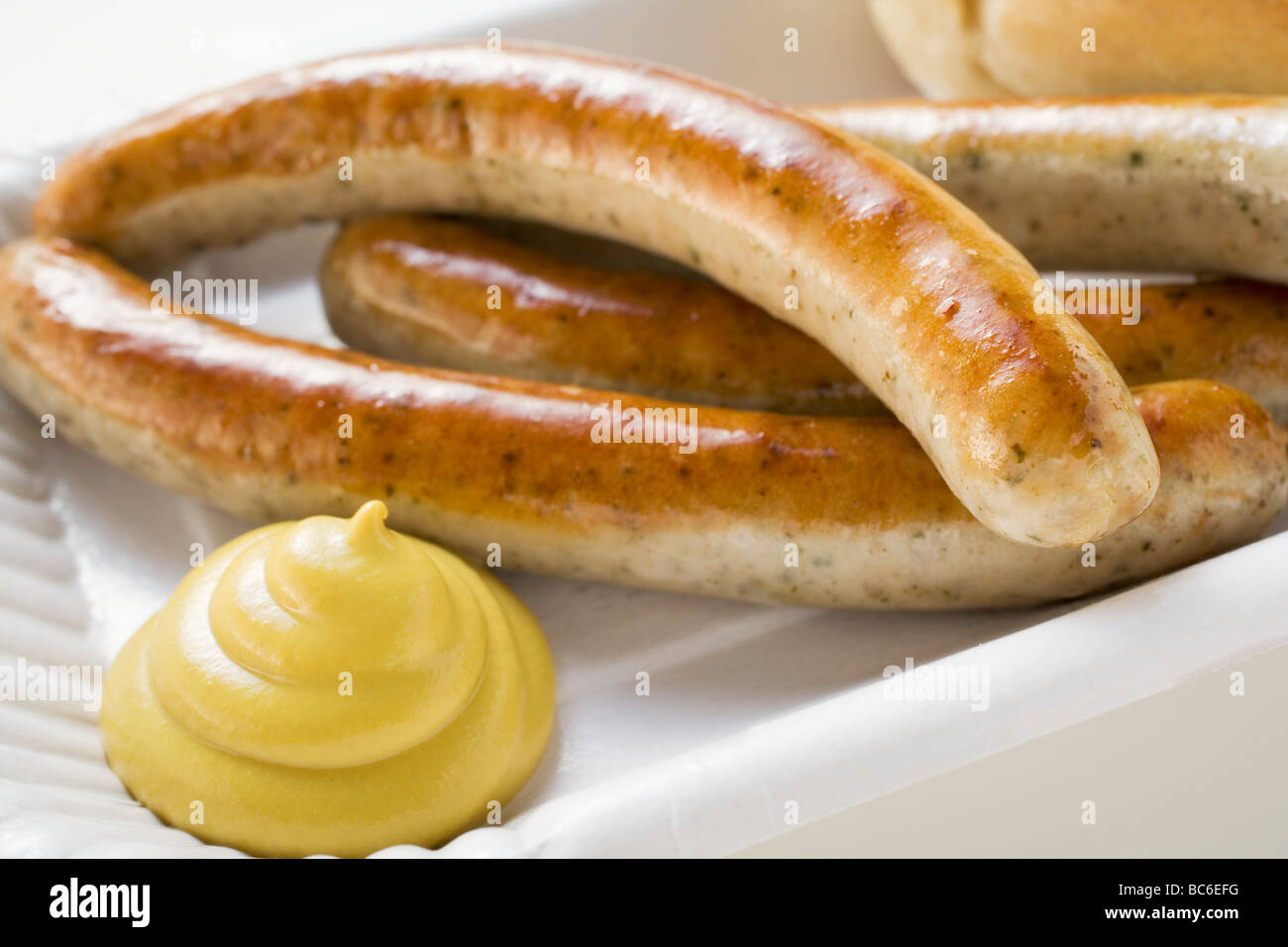 Salsicce (bratwursts) con senape sul piatto di carta - Foto Stock