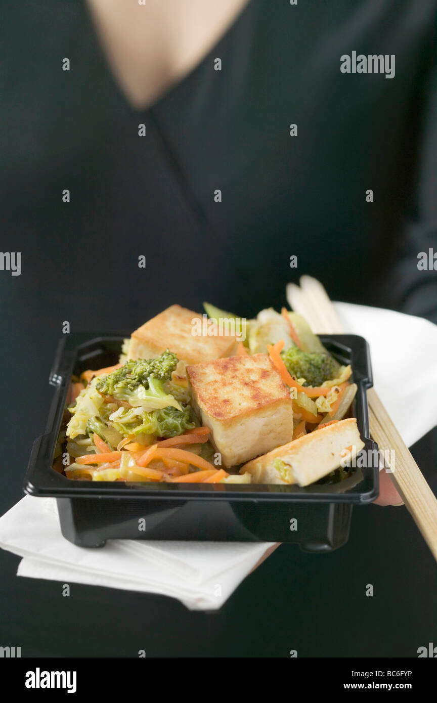 Tofu fritto con verdure, donna in background (Giappone) - Foto Stock