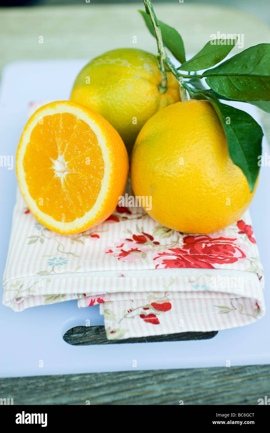 Due arance con foglie e semi di una clementina - Foto Stock
