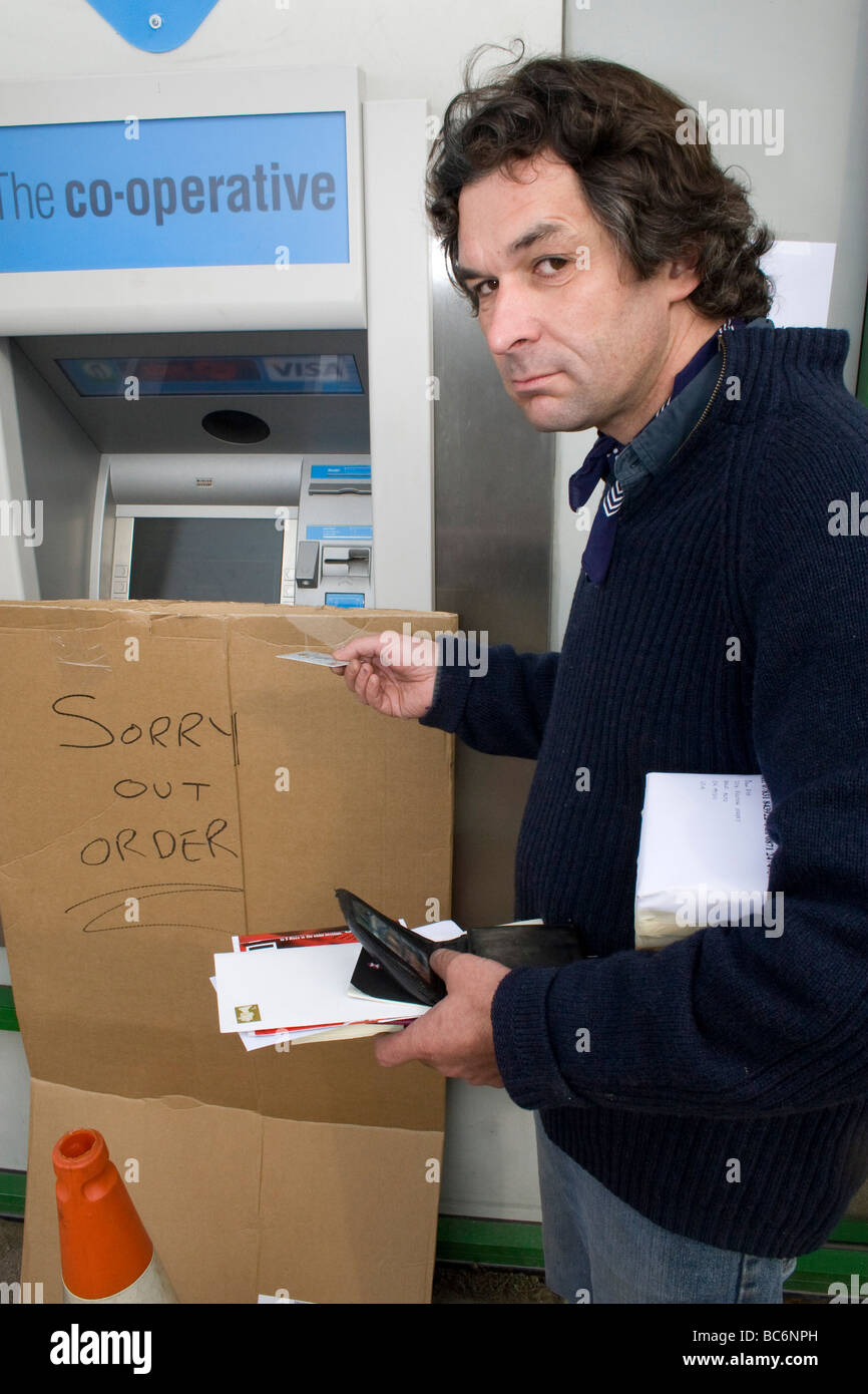 L'uomo guarda rabbiosamente scontroso perché bancomat non funziona Foto Stock