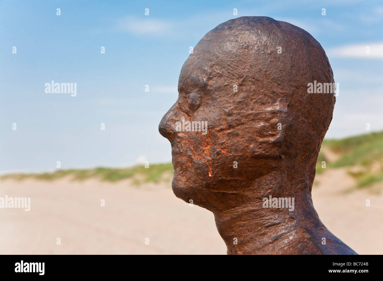 Uno di Antony Gormley "un altro posto' iron man statue. Crosby Beach, Liverpool, Merseyside, Regno Unito. Foto Stock