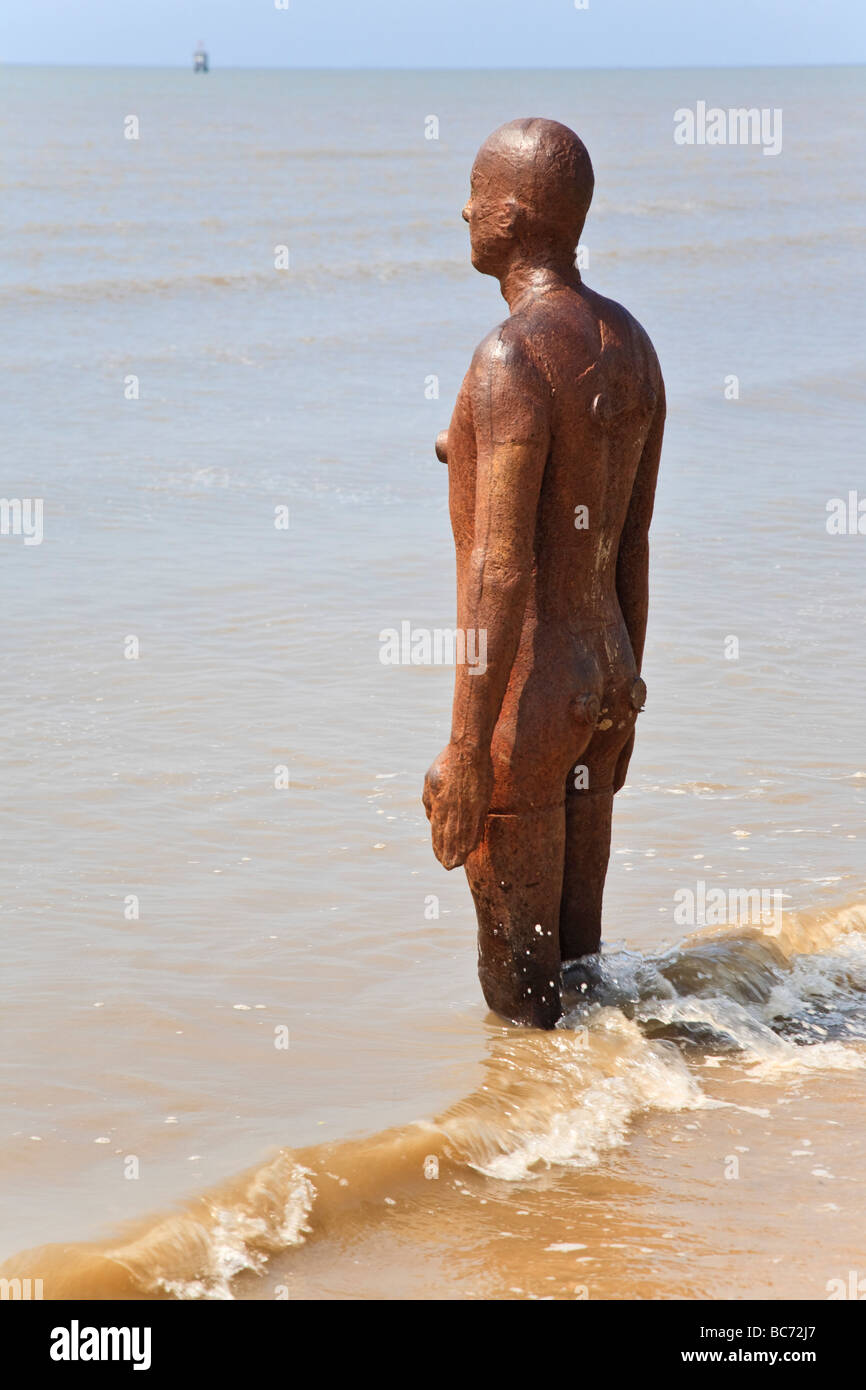 Uno di Antony Gormley "un altro posto' iron man statue. Crosby Beach, Liverpool, Merseyside, Regno Unito. Foto Stock