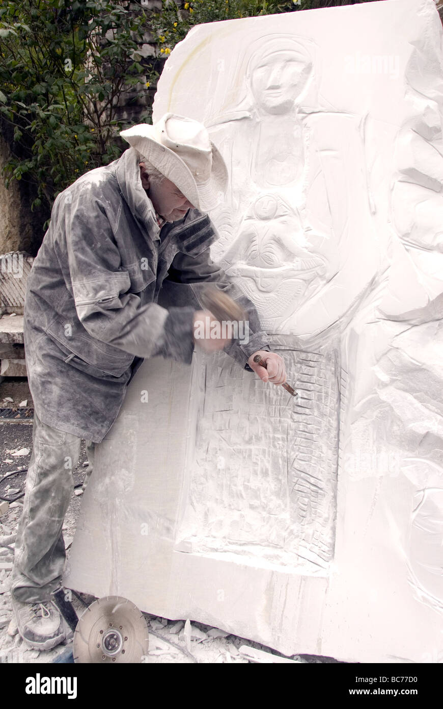 Mario del Sarto, ingenuo scultore stradale lavorando su una Madonna con Bambino, scultura alla sua aria aperta studio nelle montagne di carrara Foto Stock