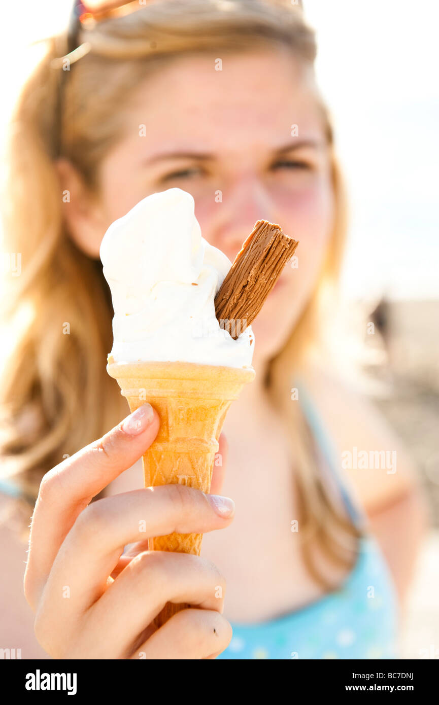 Una ragazza adolescente tenendo un gelato morbido cono con scaglie di cioccolato in esso 99 Wales UK Foto Stock