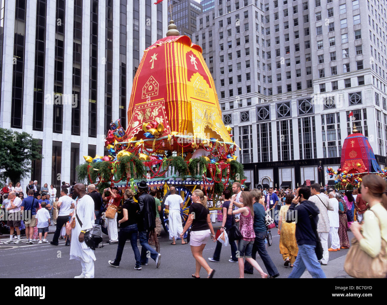 New York City colorful Hare Krishna Hindu festival parata galleggiante sulla Fifth Avenue a Midtown Manhattan. Folla che guarda la processione religiosa indù. Foto Stock