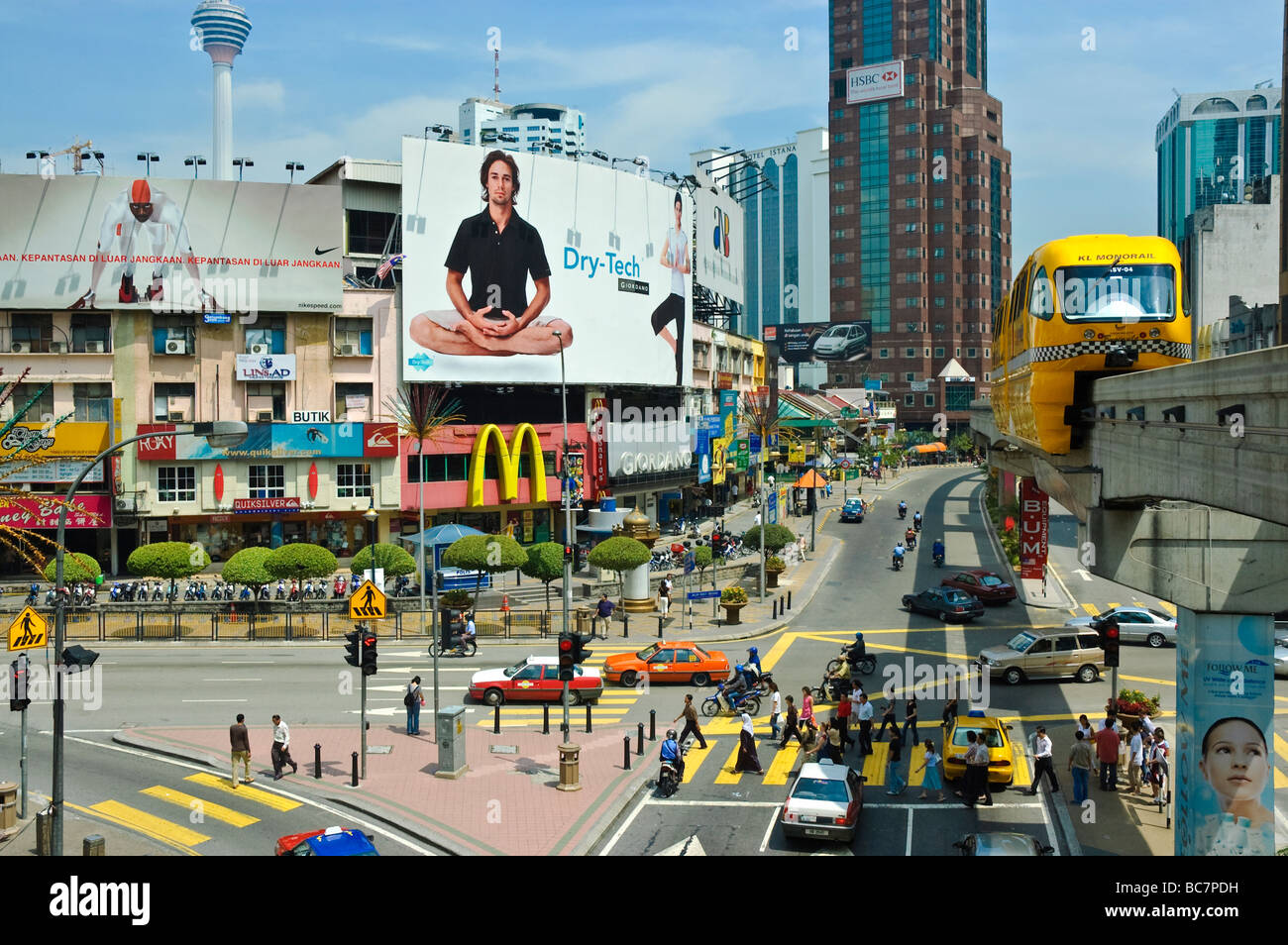 Un treno monorotaia scorre al di sopra di un grande incrocio in Bukit Bintang quartiere dello shopping di Kuala Lumpur, Malesia, se l'Asia. Trasporto; scena urbana Foto Stock