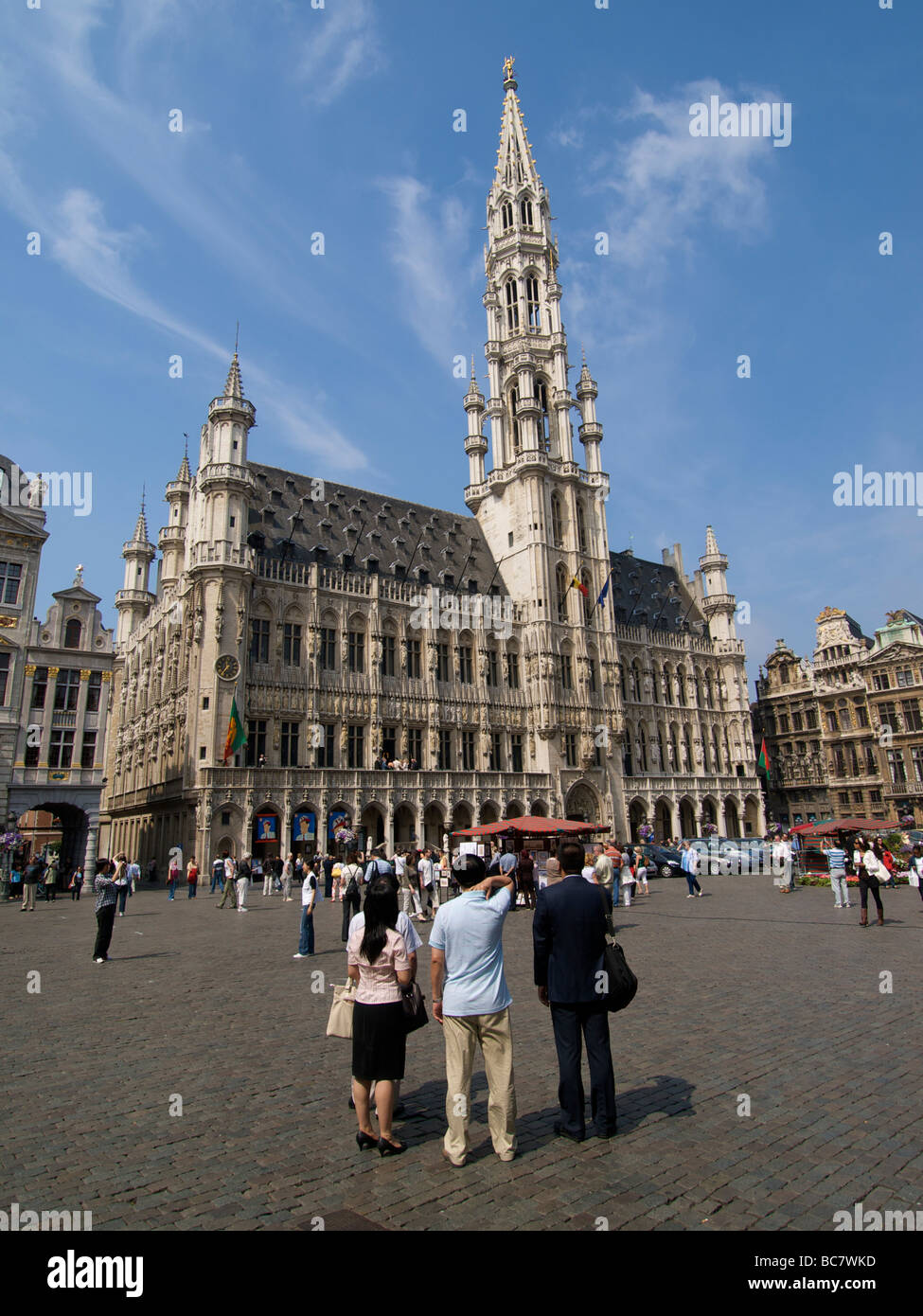 Oriental turisti in cerca in soggezione a Bruxelles municipio edificio sul Grote Markt la piazza principale di Bruxelles Belgio Foto Stock