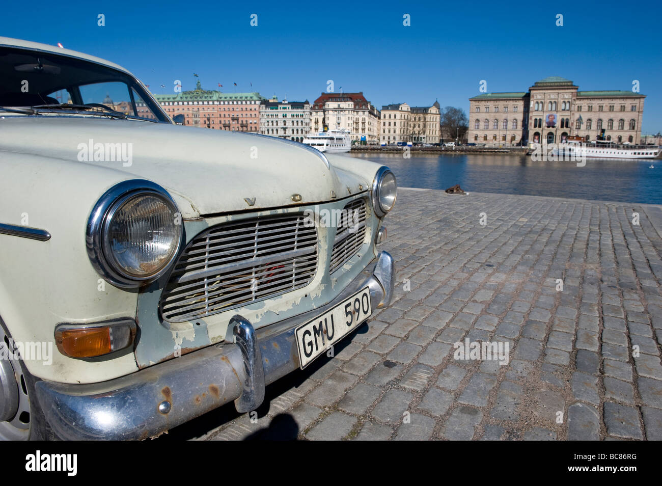 Un vecchio Volvo Car parcheggiata da the Waterside a Stoccolma, Svezia, con il Museo Nazionale in background Foto Stock
