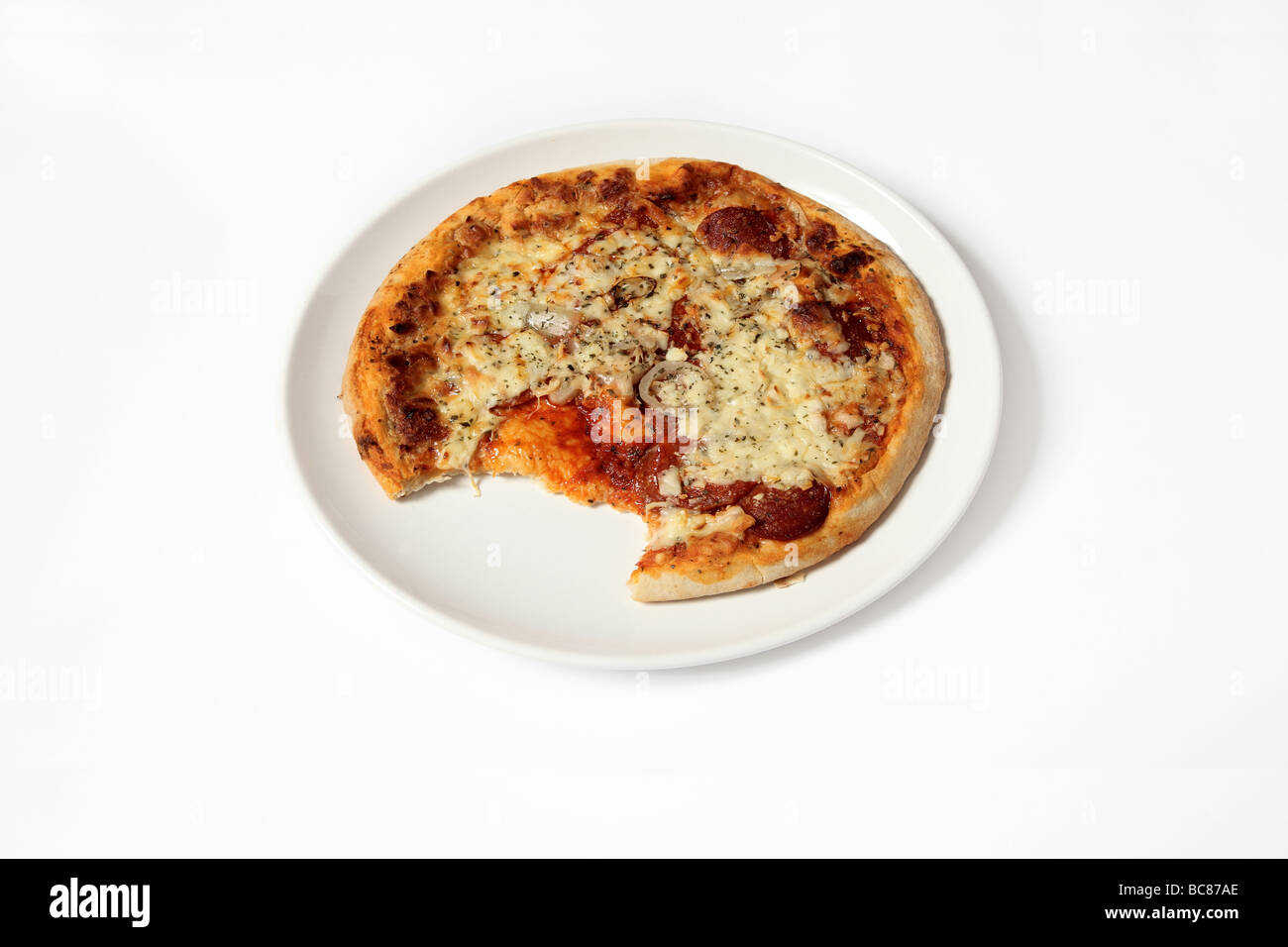 Pizza su una piastra con un morso mancante. Foto Stock