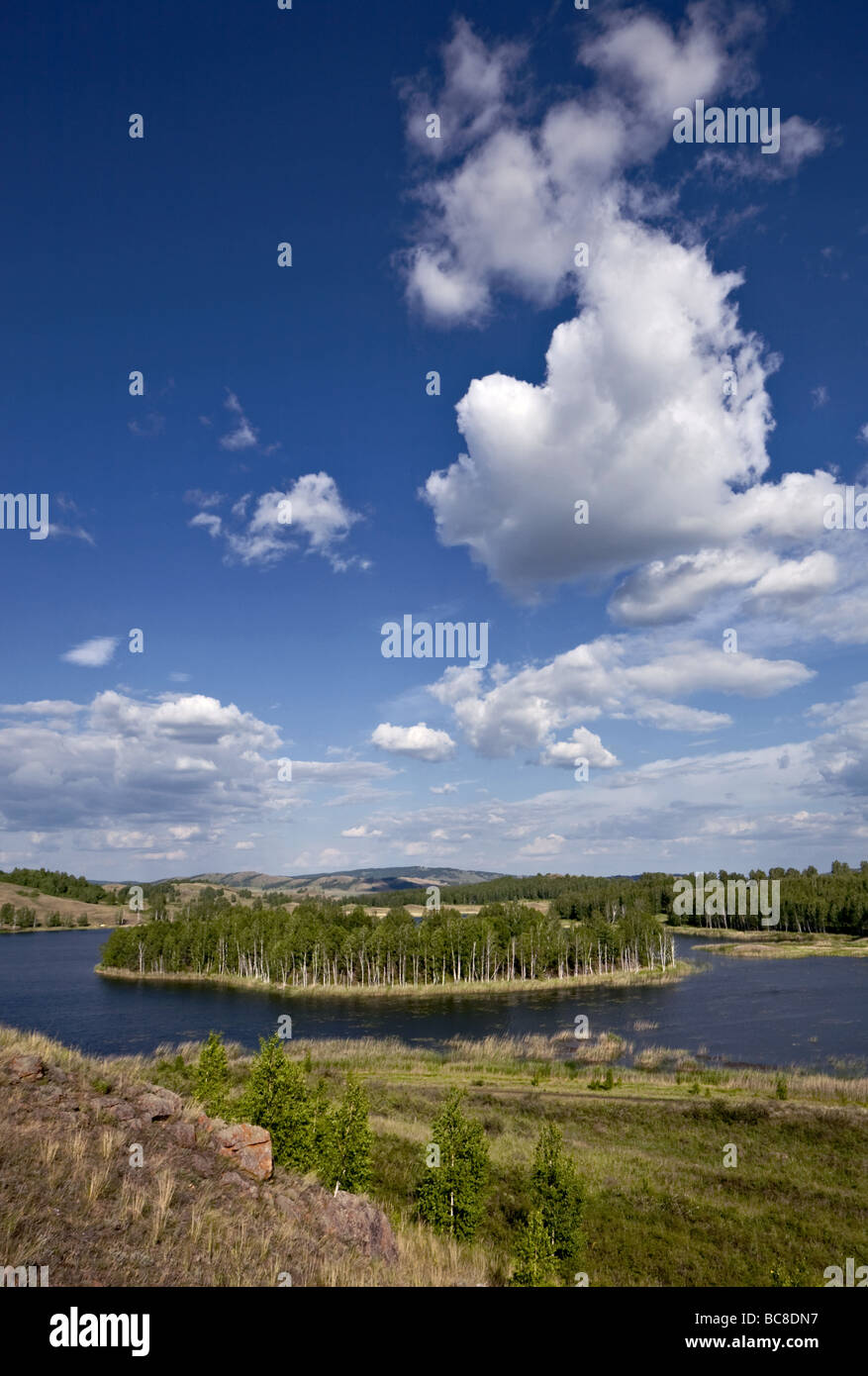 Cloudscape oltre l'isola nel mezzo del lago Foto Stock