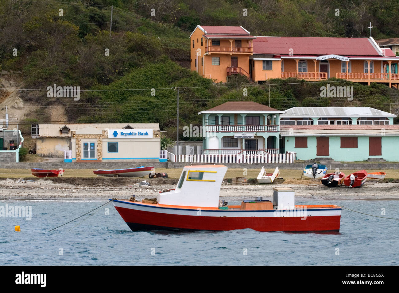 Rosso barca al di ancoraggio con spiaggia, chiesa e negli edifici, Petit Martinique, dei Caraibi. Foto Stock Rosso barca al di ancoraggio con spiaggia, chiesa e negli edifici, Petit Martinique, dei Caraibi. Foto Stock