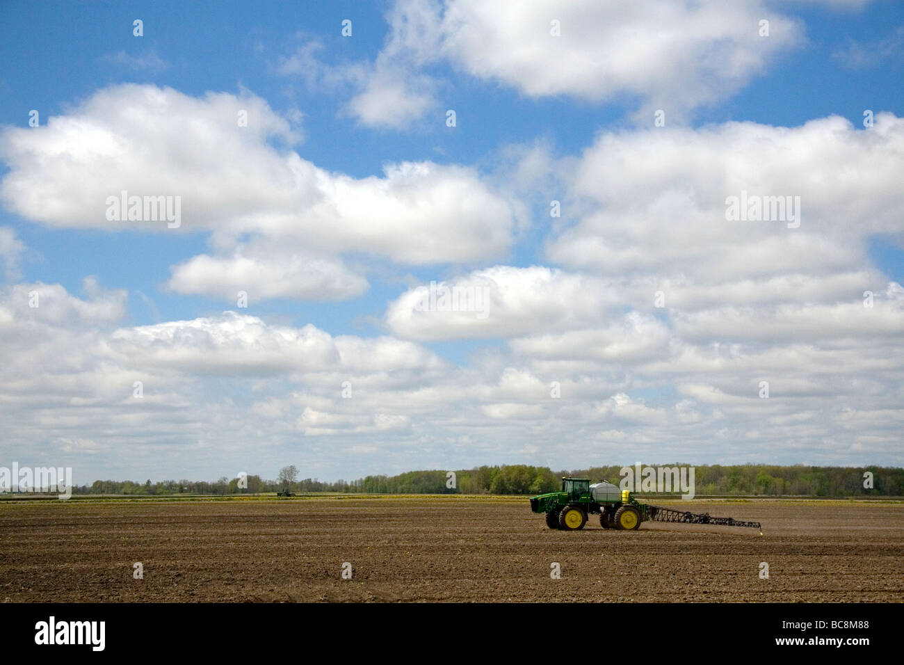 La spruzzatura del trattore erbicida coltivato su terreno raccolto in Lapeer County Michigan STATI UNITI Foto Stock