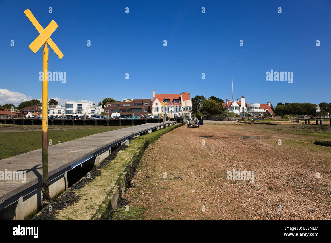 Indicatore di avvertimento sulla fine del pontile a Warsash a bassa marea con una vista del villaggio Spiaggia e Pub Hampshire REGNO UNITO Foto Stock