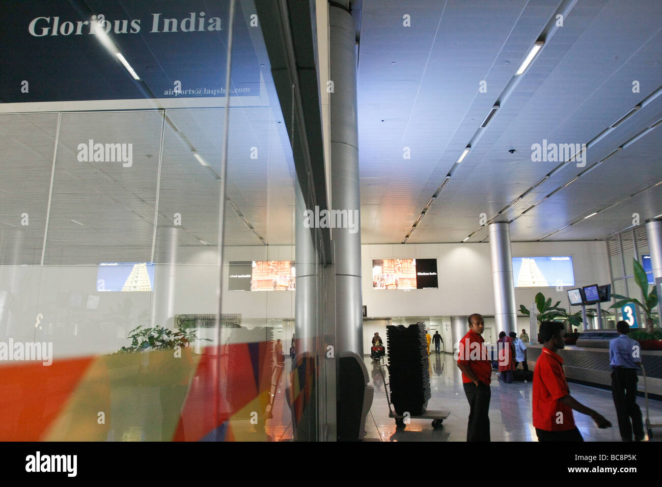 I passeggeri del trasporto aereo attendere per i loro bagagli nella sala arrivi dell'aeroporto internazionale Rajiv Gandhi a Hyderabad in India Foto Stock