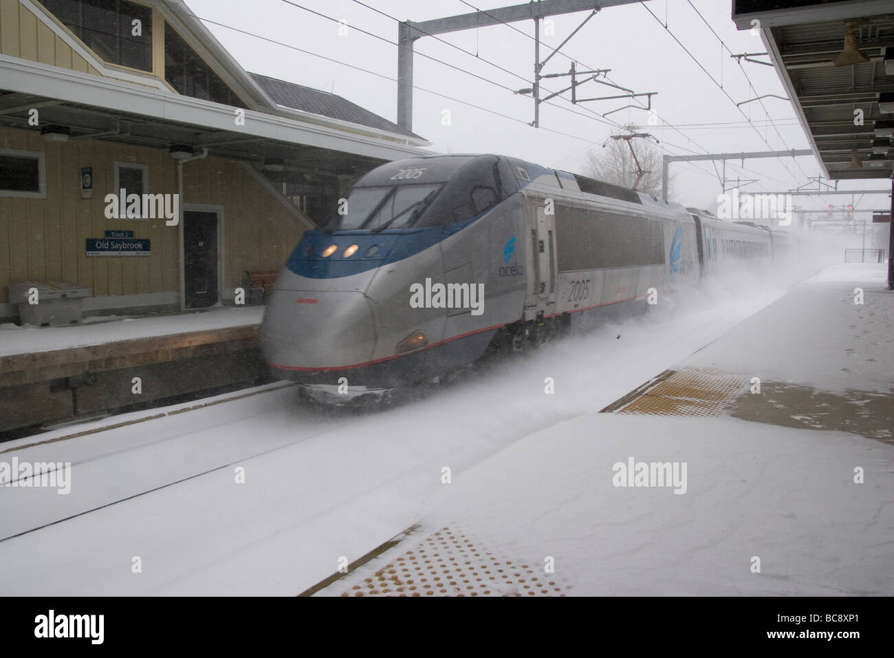 Un Amtrak Acela ad alta velocità per i passeggeri il treno passa attraverso la Old Saybrook, CT, Stati Uniti d'America per la stazione passeggeri durante una bufera di neve Foto Stock