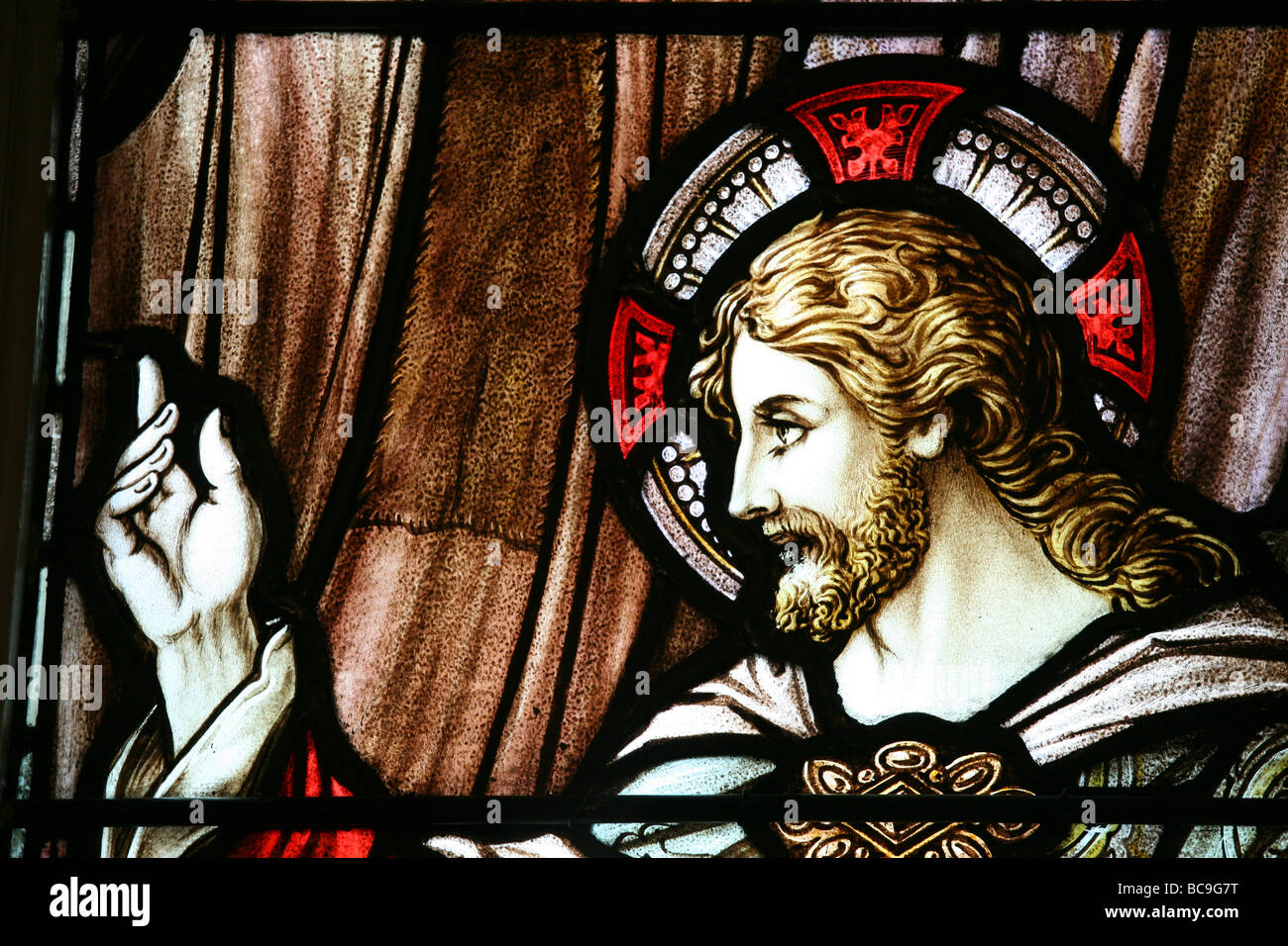 Parte di una finestra di vetro colorato con l immagine di Cristo alzando la mano. Foto Stock