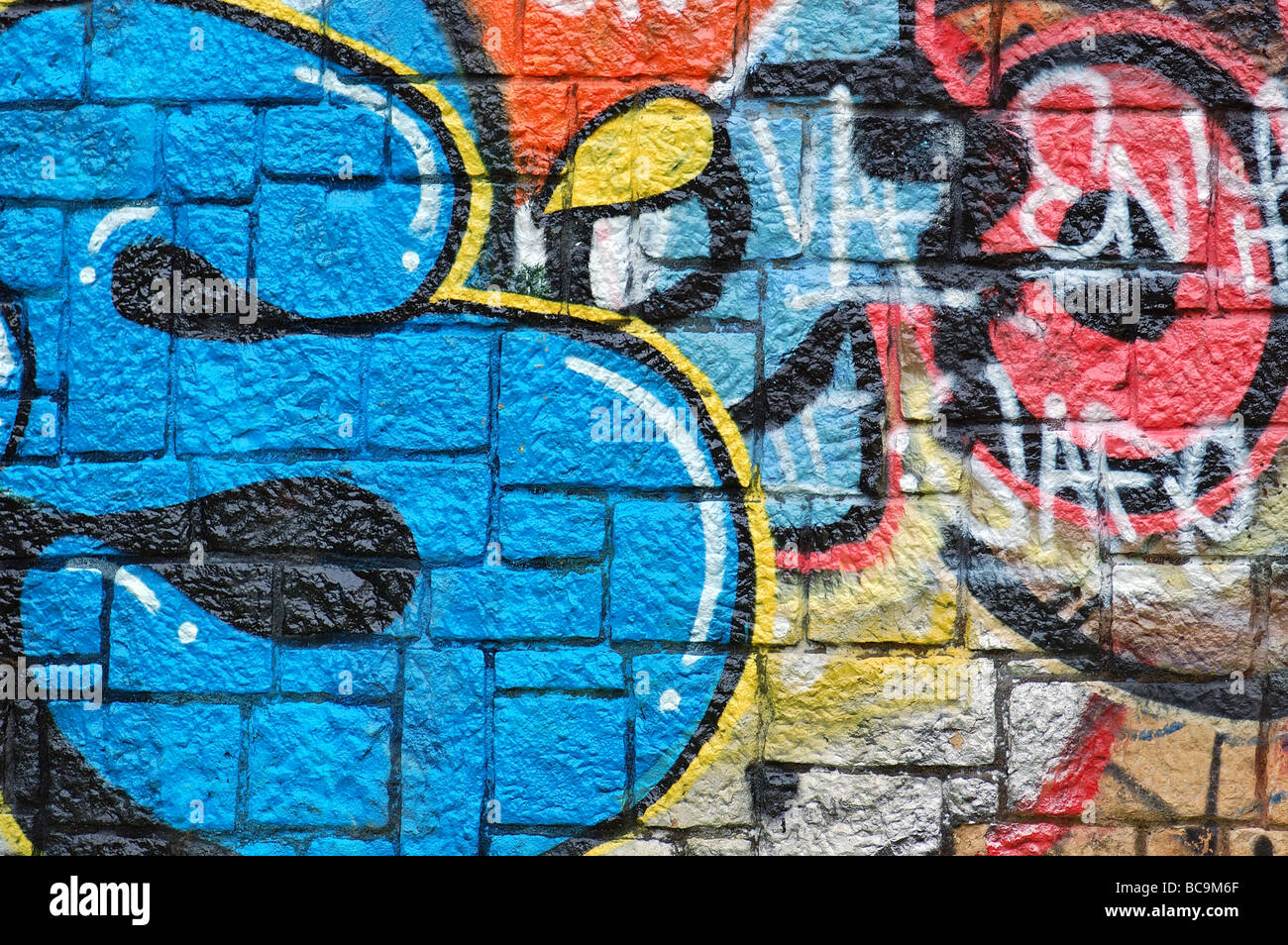 Muro di pietra superficie coperta di graffiti. Urban street art background. Foto Stock