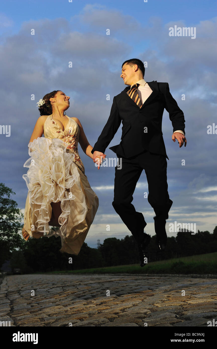Coppia felice nel loro giorno di nozze all'aperto, saltando, emozioni, felice, gioia, due persone per sempre, felice, divertente, matrimonio divertente, vibrazioni matrimonio, unico matrimonio Foto Stock
