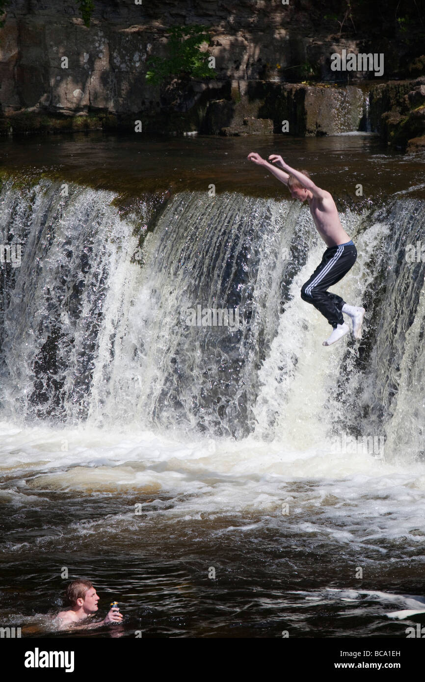 Giovani saltando nel fiume Swale Richmond Cittadina Georgiana North Yorkshire Foto Stock