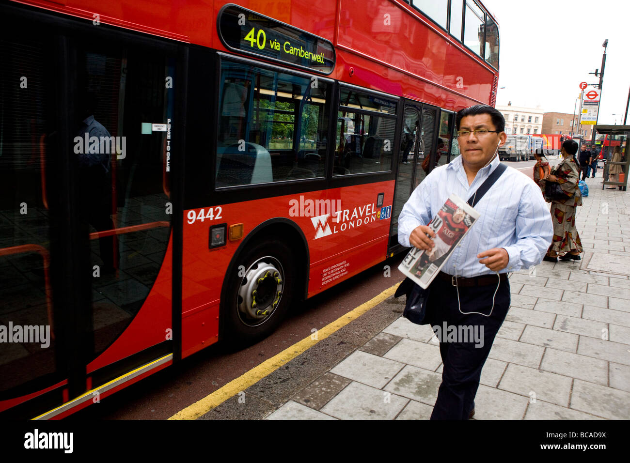 Uomo che corre per bus quotidiano di contenimento Foto Stock