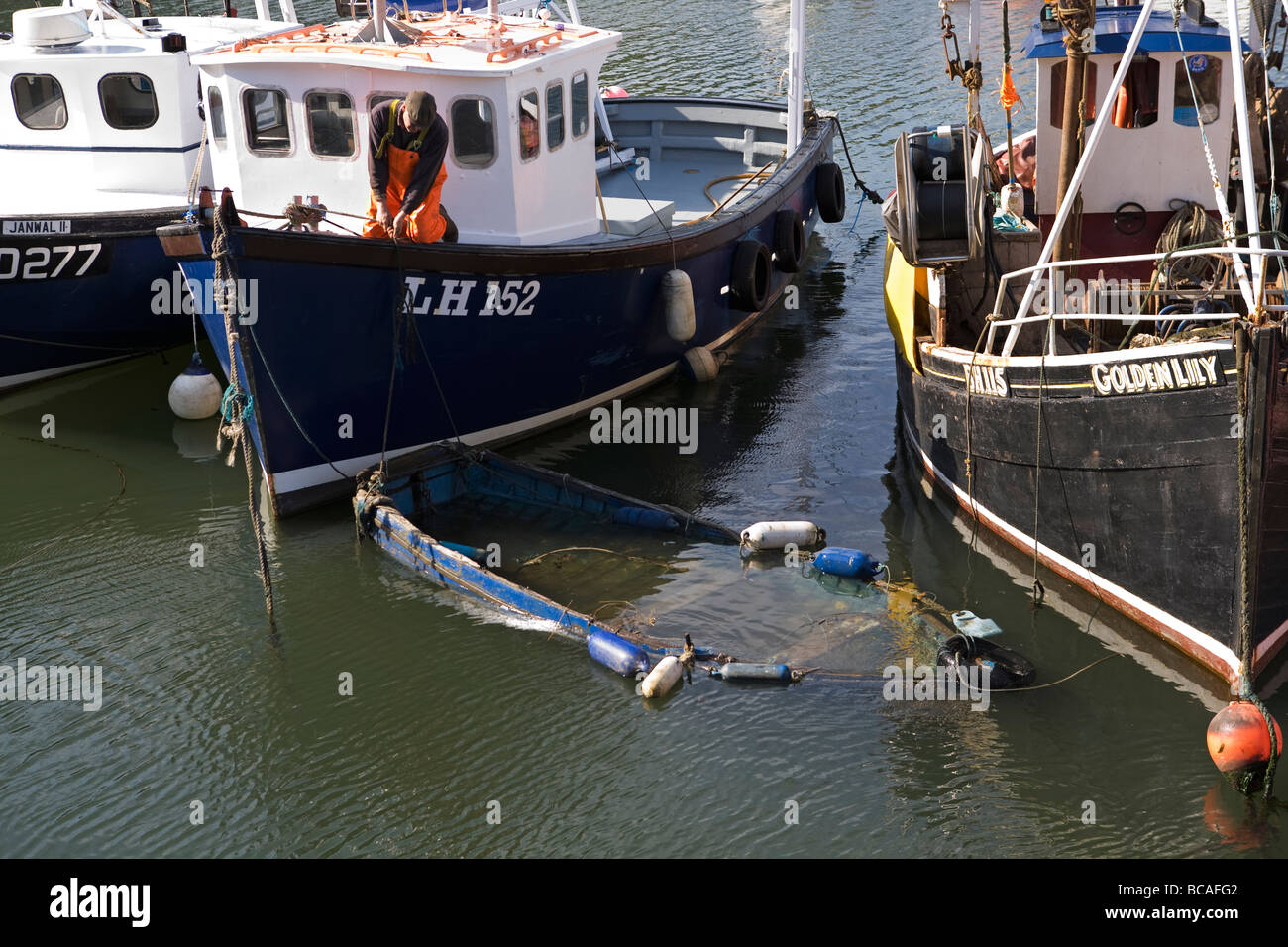 Barca affondata essendo sollevata da pescatore entro Roker marina, Sunderland, England, Regno Unito Foto Stock