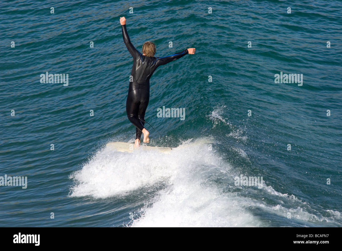 Un uomo che naviga in un longboard a Refugio punto. Foto Stock