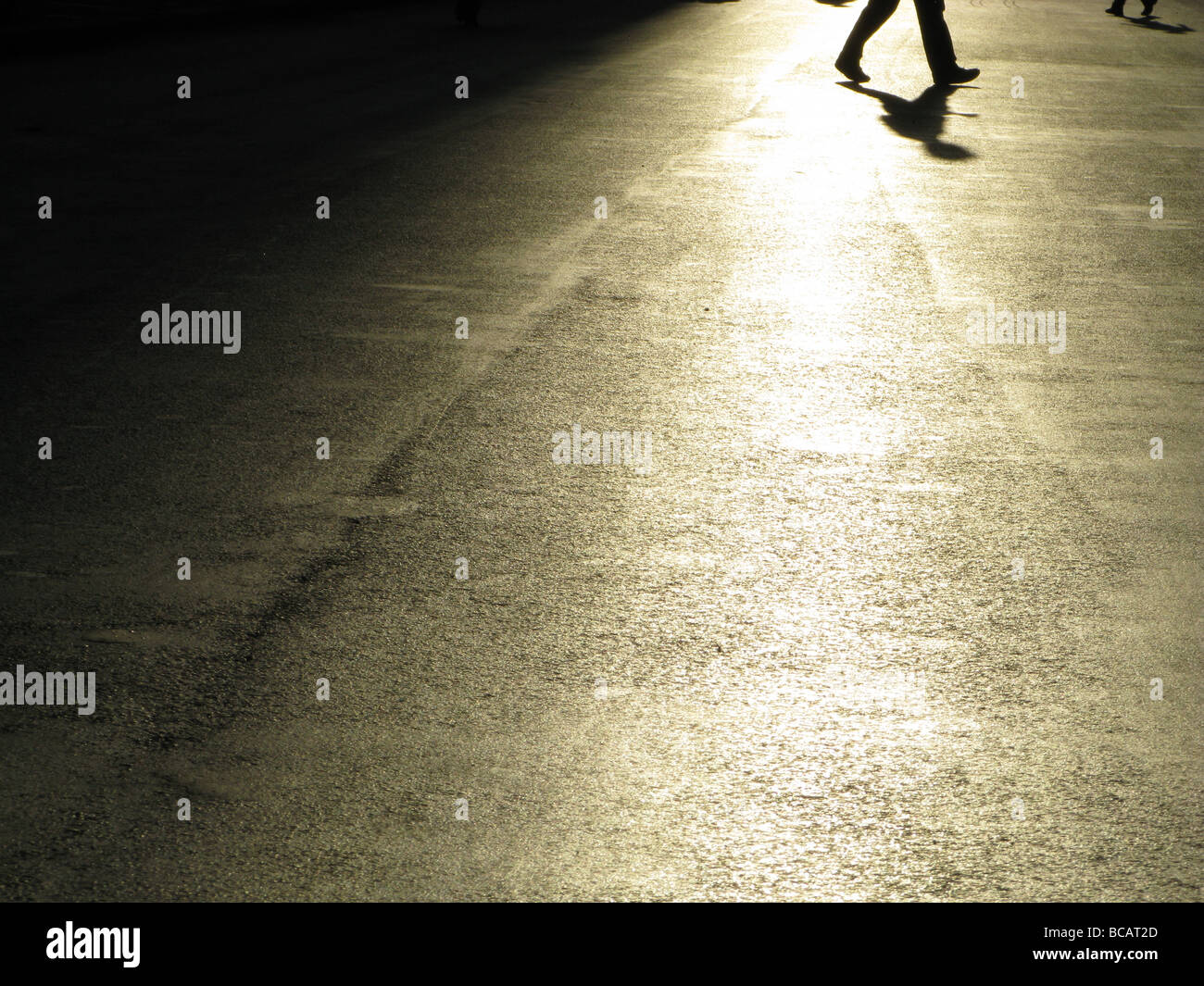 Una persona che cammina nella vuota strada in città città Foto Stock