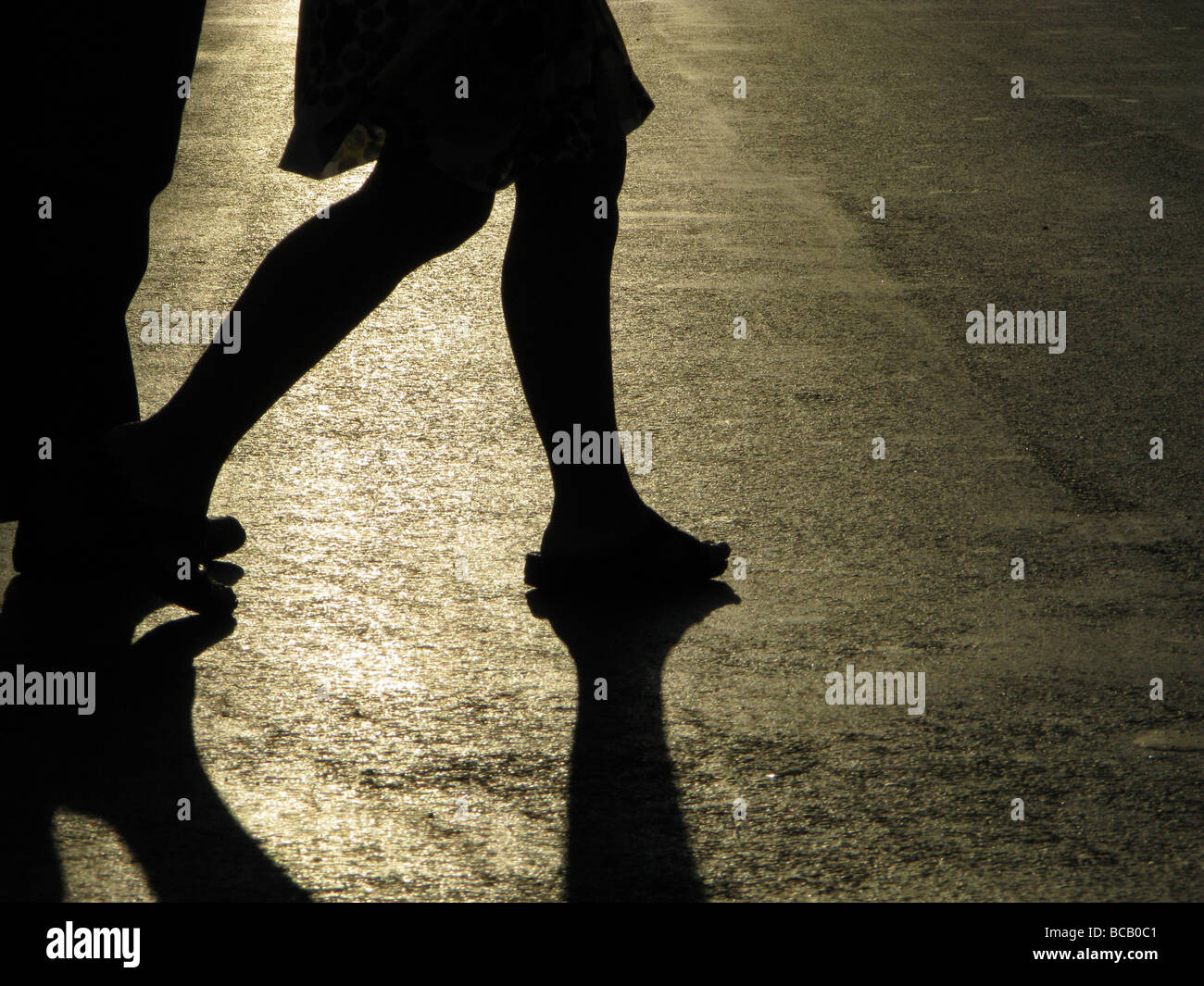 Una persona che cammina nella vuota strada in città città Foto Stock