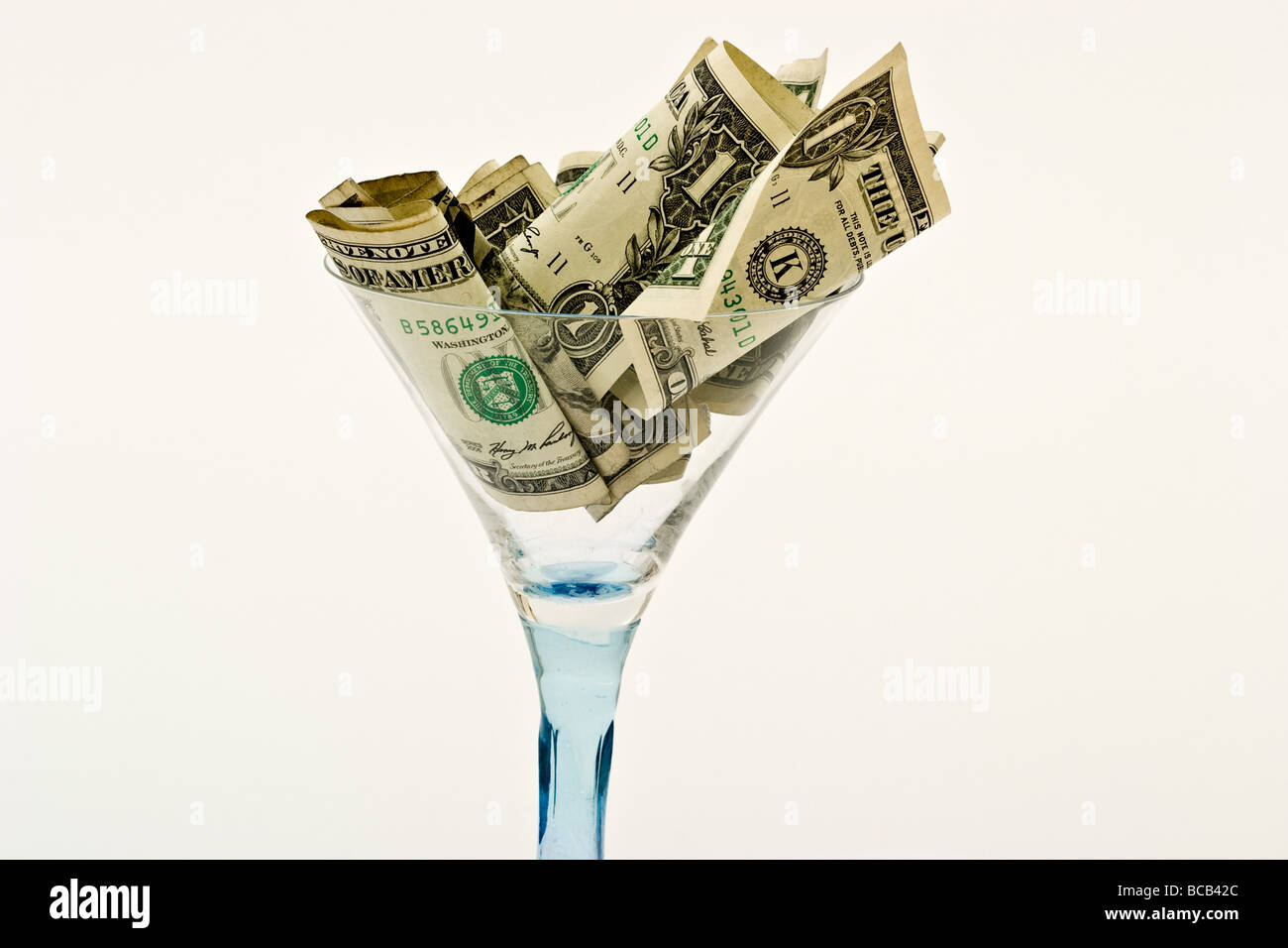 Le fatture del dollaro in un vuoto di vetro martini Foto Stock