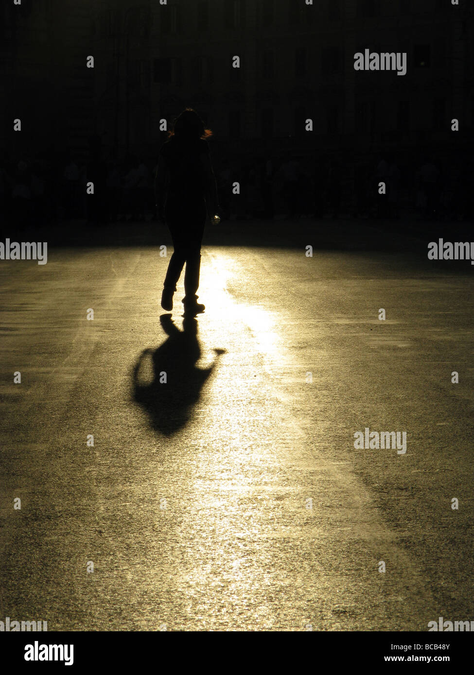 Una persona che cammina nella vuota strada in città città Foto Stock