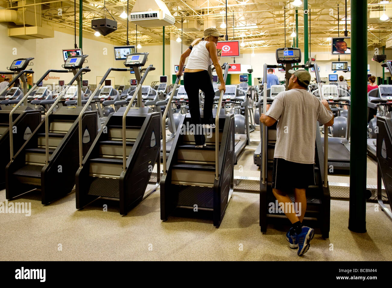 Televisori sintonizzati su canali diversi deviare gli appassionati di esercizio a un Southern California centro fitness Foto Stock