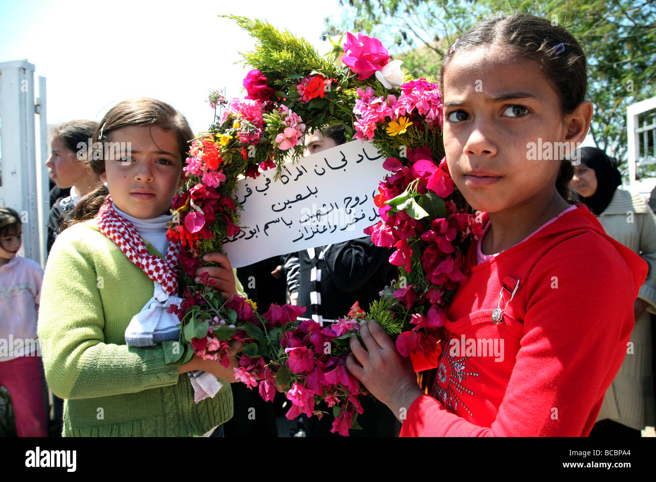 Le ragazze palestinesi tenendo una corona a un funerale in Cisgiordania villaggio di Bi'lin. Foto Stock