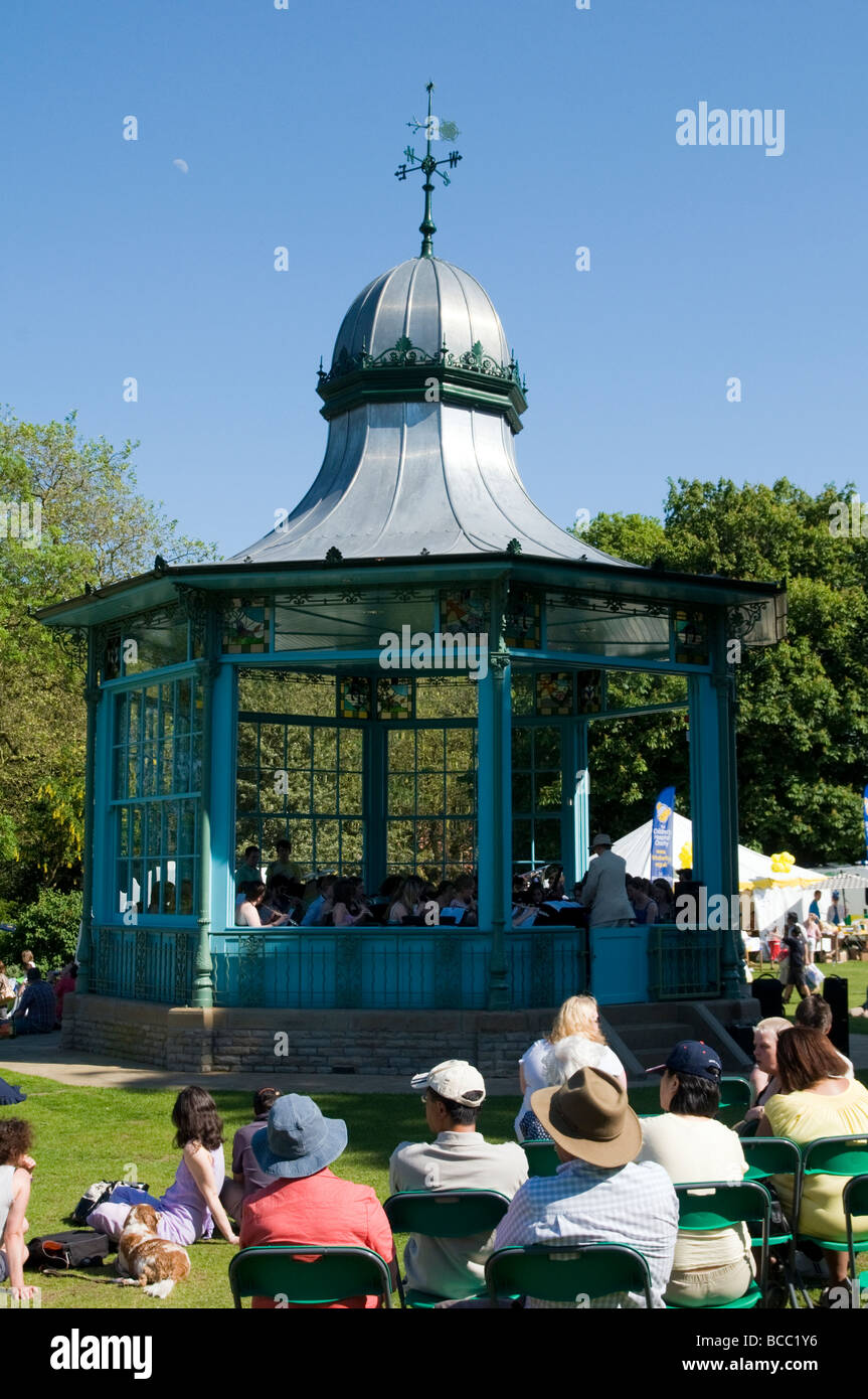 La gente seduta ascoltando la band che suona musica in Bandstand a Weston Park Sheffield South Yorkshire Inghilterra Foto Stock