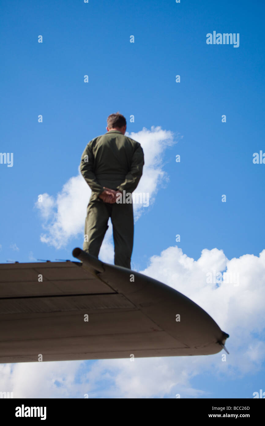 Ingegnere di aeromobili in piedi su un aeromobile ala ad un campo di aviazione militare in Inghilterra Foto Stock