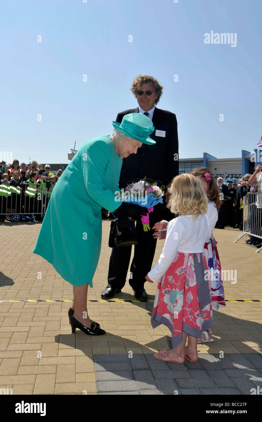 La regina Elisabetta II la ricezione di un mazzo di fiori da un bambino durante la sua visita a Weymouth e Portland Academy a vela nel Dorset Foto Stock