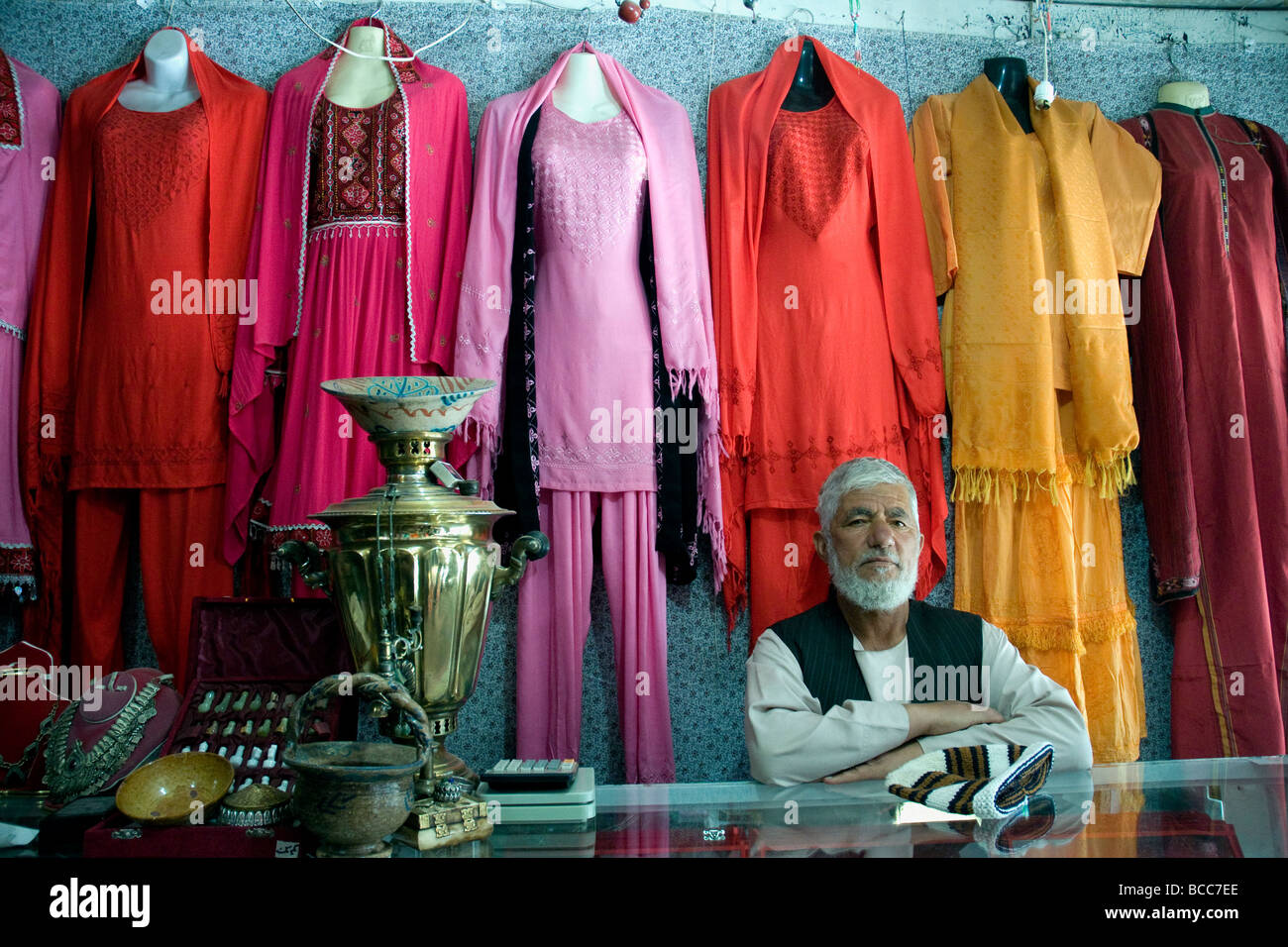 Un bottegaio a Kabul il Chicken Street, Afghanistan, con colorati capi di abbigliamento femminile mai visto in pubblico Foto Stock