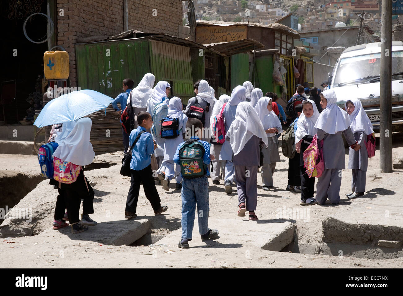 Scolari--velati di ragazze e ragazzi bareheaded--in una città di Kabul street, Afghanistan Foto Stock