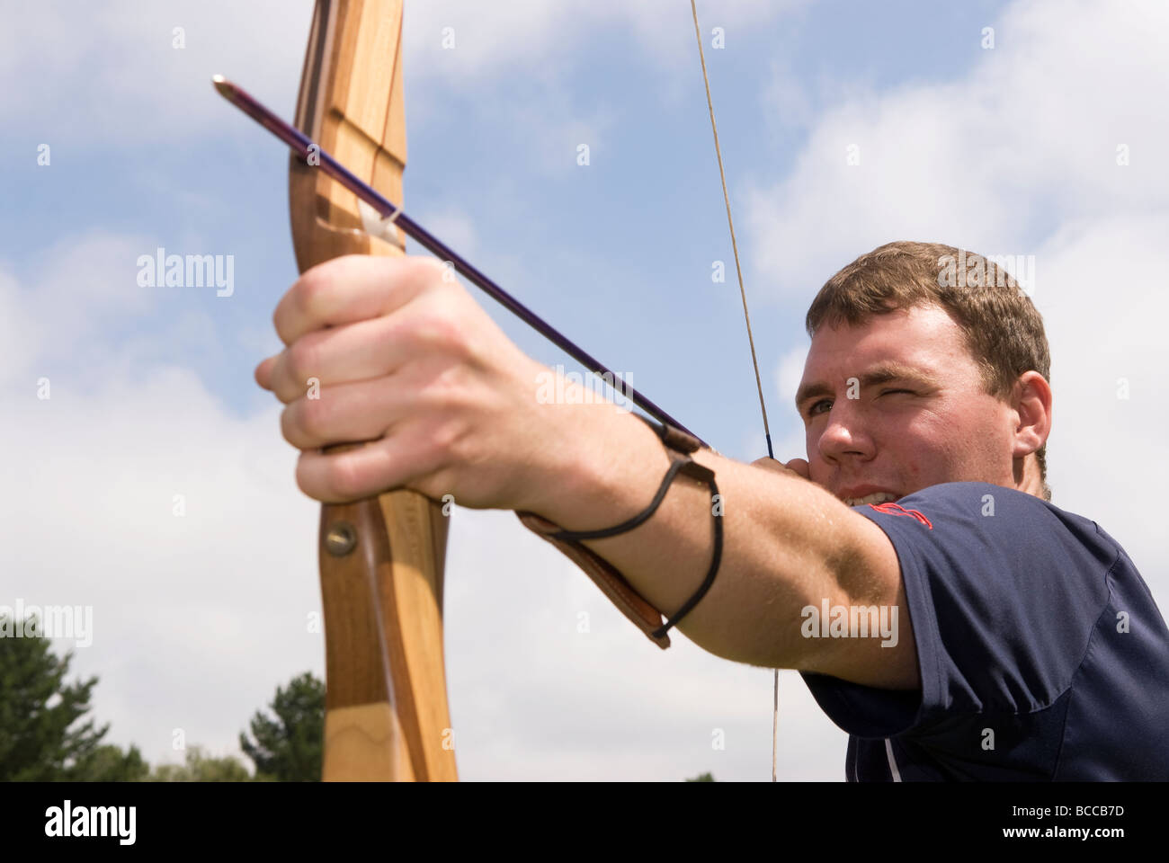 21 anno vecchio cercando il tiro con l'arco a una fiera estiva nel Blackmoor vicino Bordon, Hampshire, Regno Unito. Foto Stock