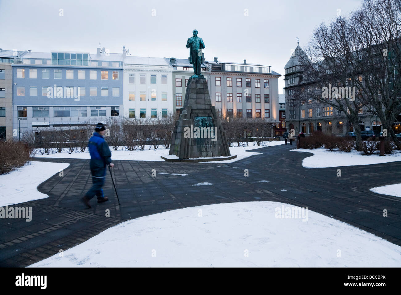 Uomo con un bastone da passeggio a piedi su Austurvollur city square Foto Stock