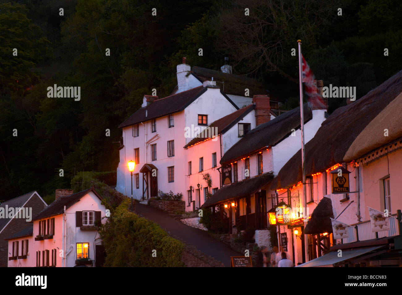 Il Rising Sun Hotel illuminati da lampade di via al tramonto sul ripido sentiero che conduce dal porto di Lynmouth North Devon Regno Unito Foto Stock