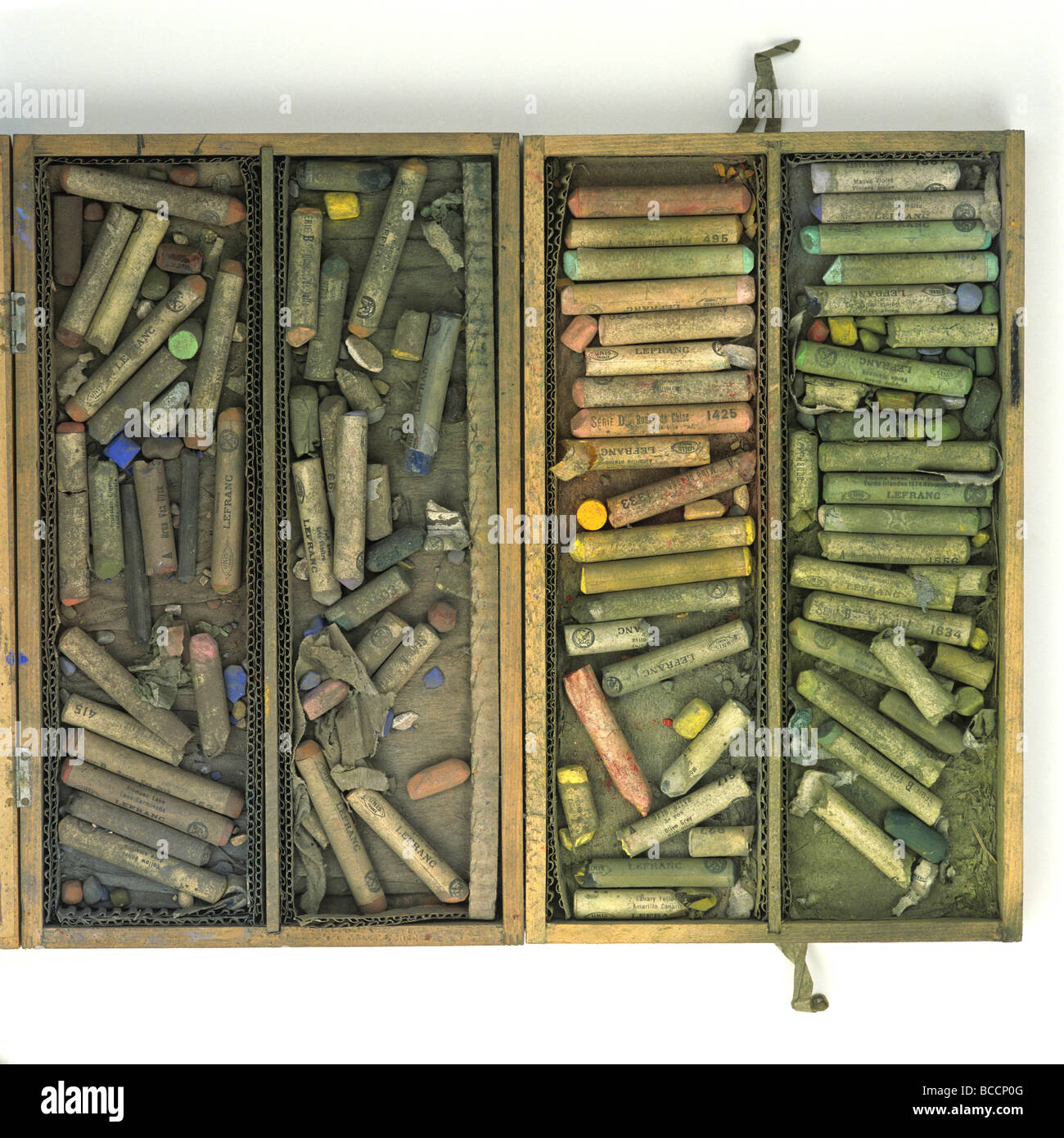 Collezione di vibranti pastelli di gesso in una scatola di legno disposta per colore e dimensioni nello spazio di lavoro di un artista Foto Stock